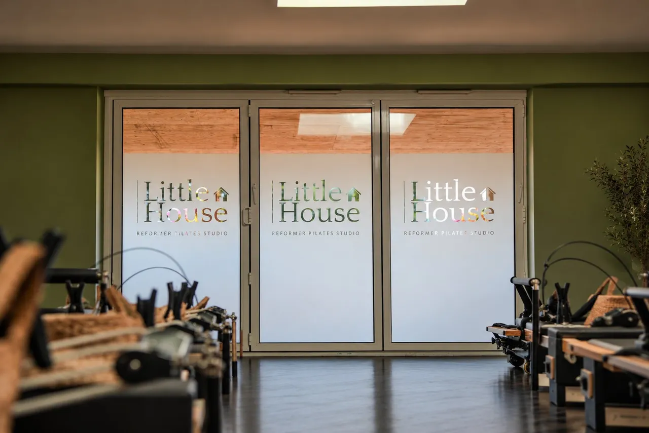 The Little House studio: frosted glass doors carrying the Little House logo, with reformers either side